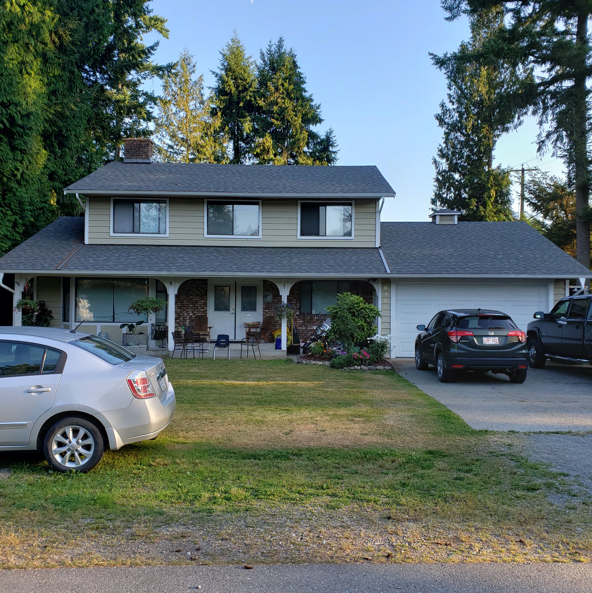 Two-story farmhouse re-roof with wraparound porch in Langley, BC by Roofking