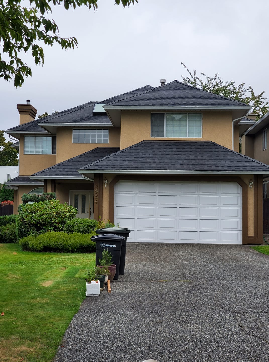 Two-story family home with new dark shingle roof in Burnaby, BC by Roofking