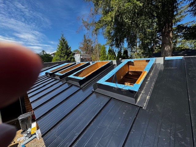 Standing seam metal roof with skylight curbs framed in Langley, BC by Roofking